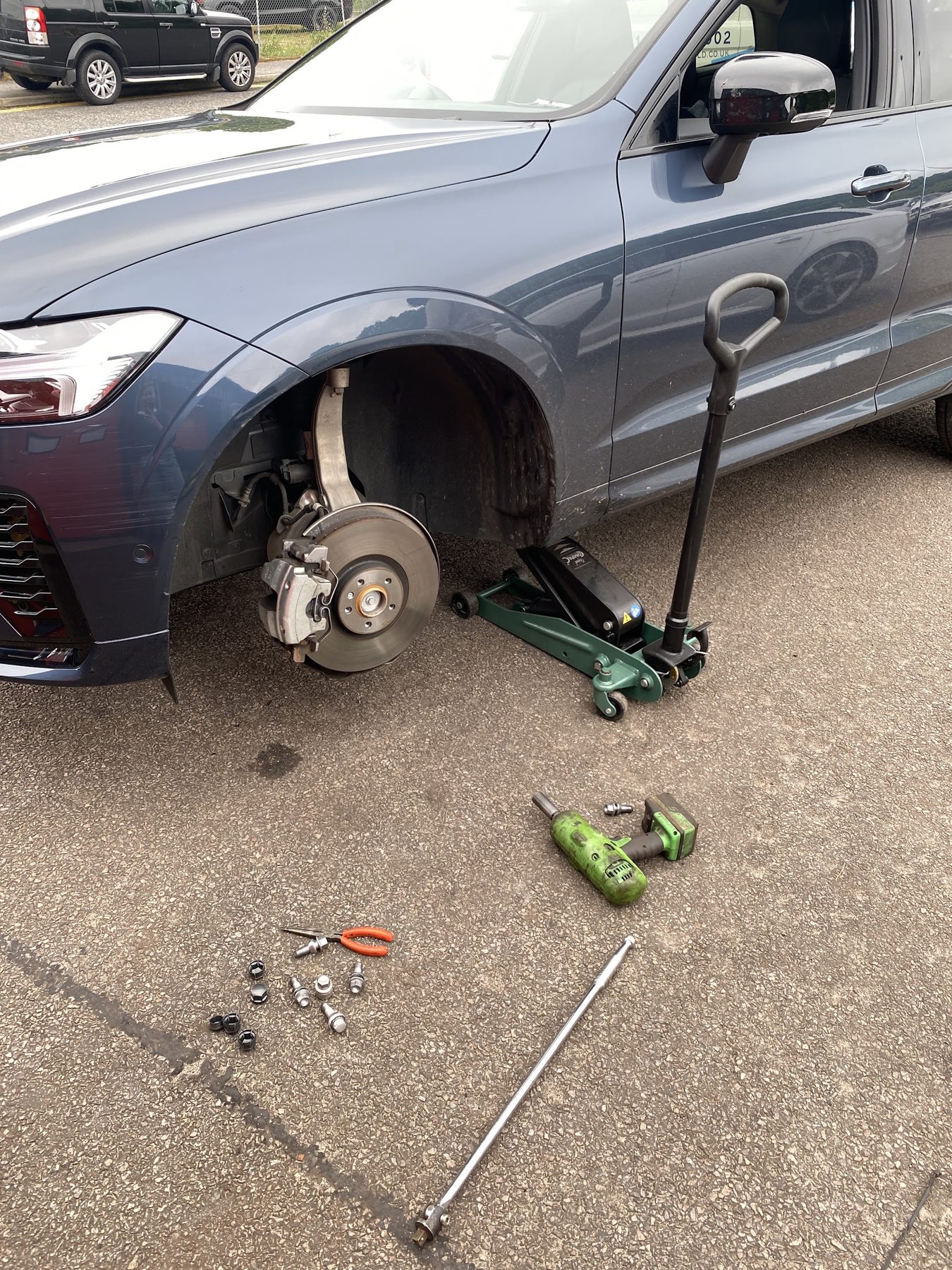 A wheel off for a puncture repair, jack and tools beside it