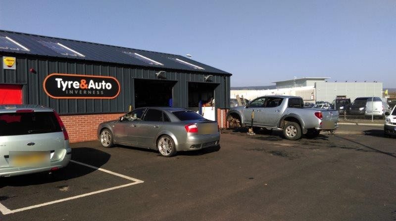The workshop exterior on Harbour Road with cars in the yard